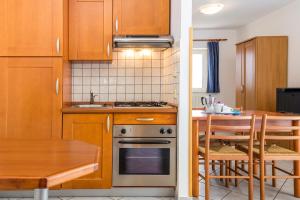 kuchnia z drewnianymi szafkami, stołem i kuchenką w obiekcie Apartment Moscenicka Draga 7766b w mieście Mošćenička Draga