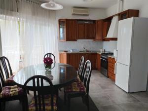 a kitchen with a table and a white refrigerator at Apartments by the sea Medveja, Opatija - 7722 in Lovran