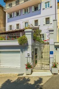 a building with two garage doors and two potted plants at Rooms by the sea Moscenicka Draga, Opatija - 7767 in Mošćenička Draga