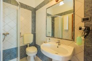 uma casa de banho com um lavatório, um WC e um espelho. em Rooms by the sea Moscenicka Draga, Opatija - 7767 em Mošćenička Draga