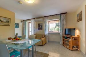 a living room with a table and a television at Apartments and rooms with parking space Nerezine, Losinj - 8049 in Nerezine