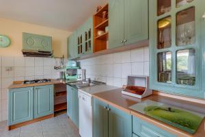 a kitchen with mint green cabinets and a sink at Apartments and rooms with parking space Nerezine, Losinj - 8049 in Nerezine