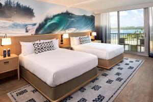 a hotel room with a large bed and a painting on the wall at Turtle Bay Resort in Kahuku