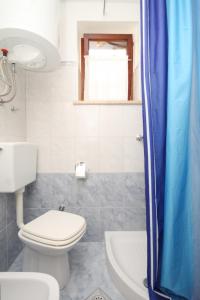 uma casa de banho com um WC, um lavatório e um chuveiro em Apartment Susak 8047a em Susak