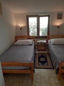 a bedroom with two beds and a window at Apartments by the sea Mali Losinj (Losinj) - 7996 in Mali Lošinj