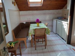 a small kitchen with a table with a vase of flowers on it at Apartments by the sea Mali Losinj (Losinj) - 7996 in Mali Lošinj