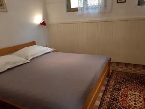 a bedroom with a bed in a room with a rug at Apartments by the sea Mali Losinj (Losinj) - 7996 in Mali Lošinj