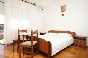 a bedroom with a bed and a table and chairs at Apartment Mali Losinj 7991b in Mali Lošinj