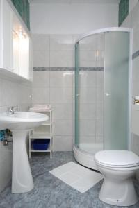 a bathroom with a shower and a toilet and a sink at Apartment Mali Losinj 7991b in Mali Lošinj