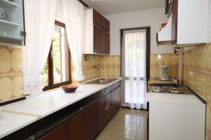 a kitchen with brown cabinets and a white counter top at Apartments with WiFi Mali Losinj (Losinj) - 7992 in Mali Lošinj