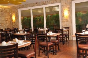 ein Restaurant mit Tischen und Stühlen in einem Raum in der Unterkunft Hotel Ipê MS in Campo Grande
