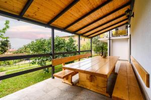 einen Holztisch auf einem Balkon mit Holzdecke in der Unterkunft Apartments with a parking space Lovran, Opatija - 7869 in Lovran