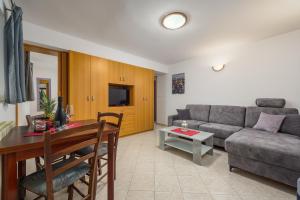 uma sala de estar com um sofá e uma mesa em Apartments with a parking space Lovran, Opatija - 7869 em Lovran