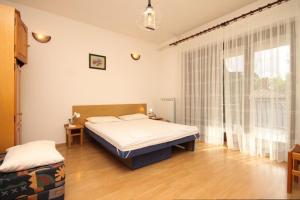 a bedroom with a bed and a large window at Apartments by the sea Icici, Opatija - 7745 in Ičići