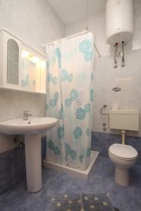 a bathroom with a toilet and a shower curtain at Apartments by the sea Icici, Opatija - 7745 in Ičići