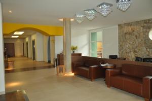 a lobby with couches and a stone wall at Hotel Ipê MS in Campo Grande