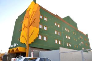 a building with a tree painted on the side of it at Hotel Ipê MS in Campo Grande