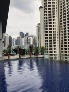 a swimming pool on the roof of a building with tall buildings at MyHabitat Residence Jalan Tun Razak in Kuala Lumpur