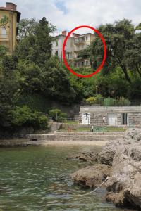 un cercle rouge devant un bâtiment près de l'eau dans l'établissement Apartments by the sea Opatija - 7830, à Opatija