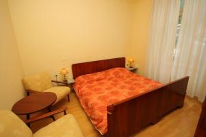 Apartments by the sea Opatija - 7830 في أوباتيا: غرفة نوم بسرير وكرسي
