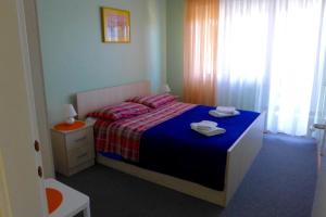 - une chambre avec un lit et une couette bleue dans l'établissement Apartments with a parking space Opatija - 7831, à Opatija