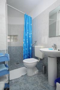 a bathroom with a toilet and a sink and a blue shower curtain at Apartment Opatija 7896a in Opatija