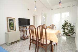 a dining room with a table and chairs and a tv at Apartment Opatija 7896a in Opatija