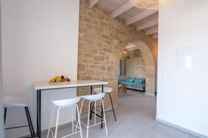 a kitchen with a table and bar stools at Alma Natura Villas Falasarna- Avgerinos Villa in Falasarna
