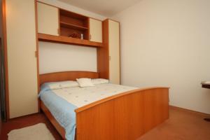 Apartments with a parking space Opatija - 7896 في أوباتيا: غرفة نوم بسرير مع اطار خشبي