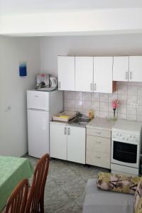 una cucina con armadi bianchi, lavandino e piano cottura di Apartments with a parking space Opatija - 7896 a Opatija