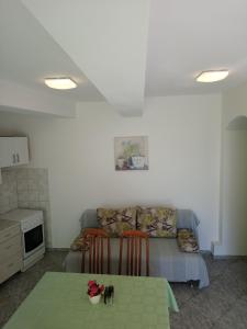 Apartments with a parking space Opatija - 7896 في أوباتيا: غرفة معيشة مع طاولة وأريكة
