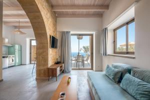 Alma Natura Villas Falasarna- Avgerinos Villa في فالاسارنا: غرفة معيشة مع أريكة وطاولة