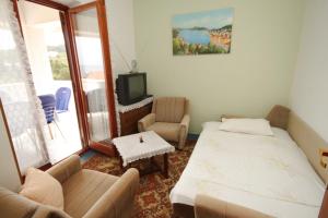 a room with a bed and a couch and a tv at Apartments and rooms by the sea Mali Losinj (Losinj) - 7977 in Mali Lošinj