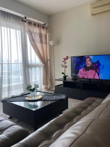 a living room with a couch and a flat screen tv at MyHabitat Residence Jalan Tun Razak in Kuala Lumpur