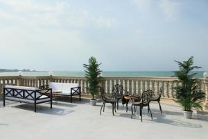 un grupo de sillas y mesas en un balcón con vistas al océano en NovART SeaVilla&Gallery Hotel, en Sumqayit