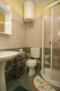 a bathroom with a toilet and a sink and a shower at Apartments with a parking space Icici, Opatija - 7988 in Ičići