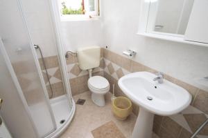a bathroom with a sink and a toilet and a shower at Apartments with a parking space Icici, Opatija - 7988 in Ičići
