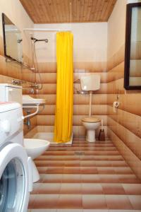 a bathroom with a toilet and a yellow shower curtain at Holiday house with a parking space Sveti Jakov, Losinj - 7950 in Nerezine