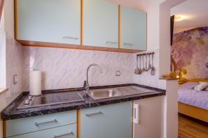 eine Küche mit einem Waschbecken und einem Bett in der Unterkunft Apartments by the sea Artatore, Losinj - 7952 in Čunski
