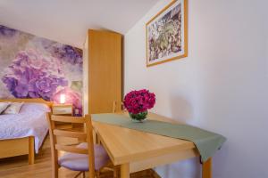 Un dormitorio con una mesa con un jarrón de flores. en Apartments by the sea Artatore, Losinj - 7952 en Čunski