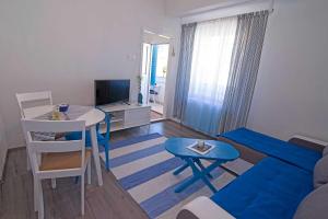 a living room with a couch and a table with a blue stool at Apartments by the sea Veli Losinj, Losinj - 7959 in Veli Lošinj