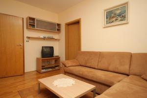 a living room with a couch and a coffee table at Apartment Mali Losinj 7979a in Mali Lošinj