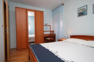 a bedroom with a bed and a table and a desk at Apartment Mali Losinj 7979a in Mali Lošinj