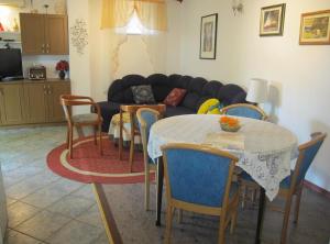 Apartments by the sea Mali Losinj (Losinj) - 8002 في مالي لوسيني: غرفة معيشة مع طاولة وكراسي وأريكة