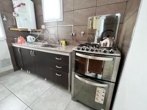 a kitchen with a stainless steel stove and a sink at Buena Vista Trevelin II in Trevelín