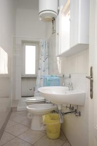 a bathroom with a sink and a toilet and a window at Apartments with a parking space Lovran, Opatija - 7693 in Lovran