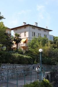 una persona está tomando una foto de un edificio en Apartments by the sea Lovran, Opatija - 7708 en Lovran