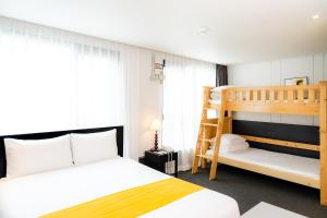 1 dormitorio con litera y escalera en Seogwipo Hills Hotel en Seogwipo