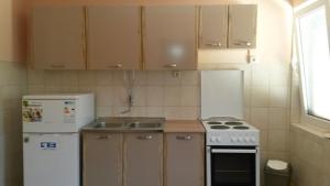 małą kuchnię z kuchenką i lodówką w obiekcie Apartment Opric 7716b w mieście Lovran