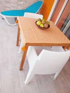 una mesa de madera con un bol de fruta. en Nouveau logement T2 avec vue sur mer et montagne, en Sainte-Rose